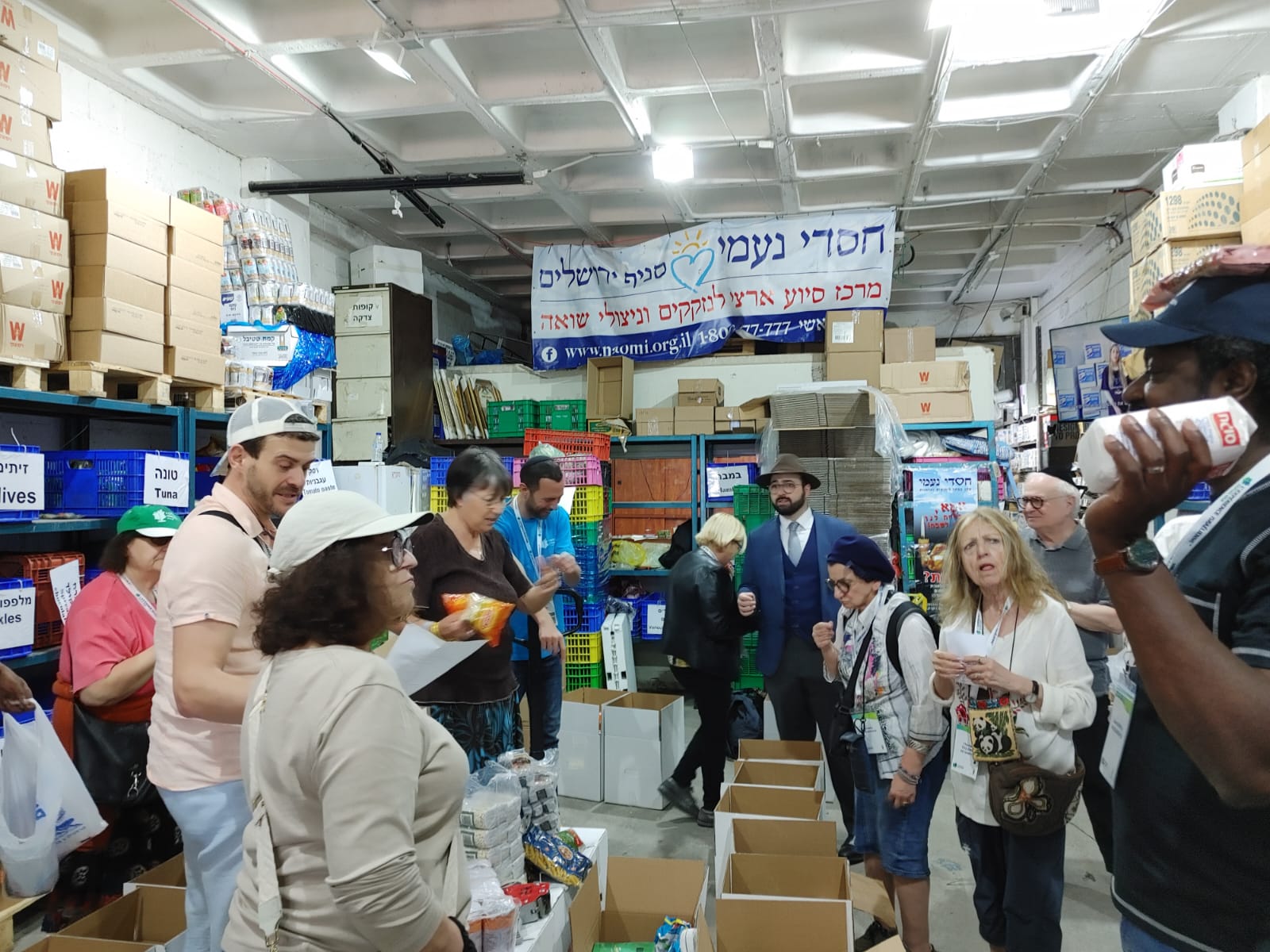 מתנדבים צרפתיים מעיר ליאון אורזים זו סלי מזון במחסן בירושלים